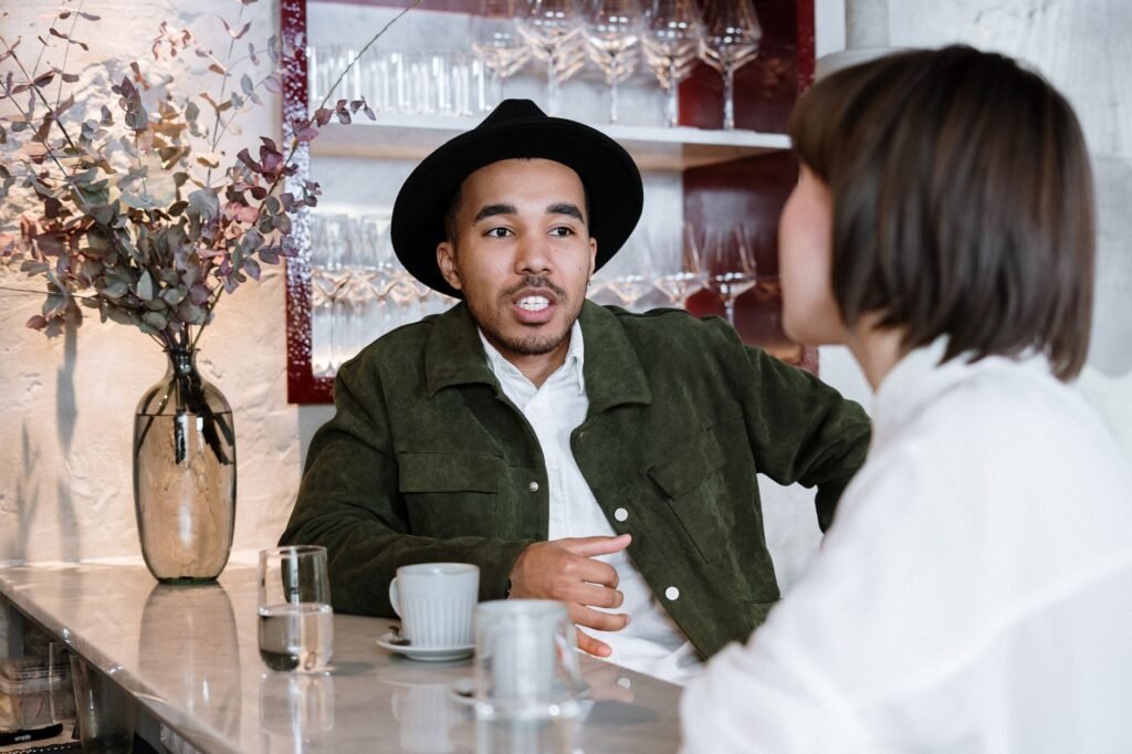 A couple enjoying a relaxed conversation in a stylish café bar setting.