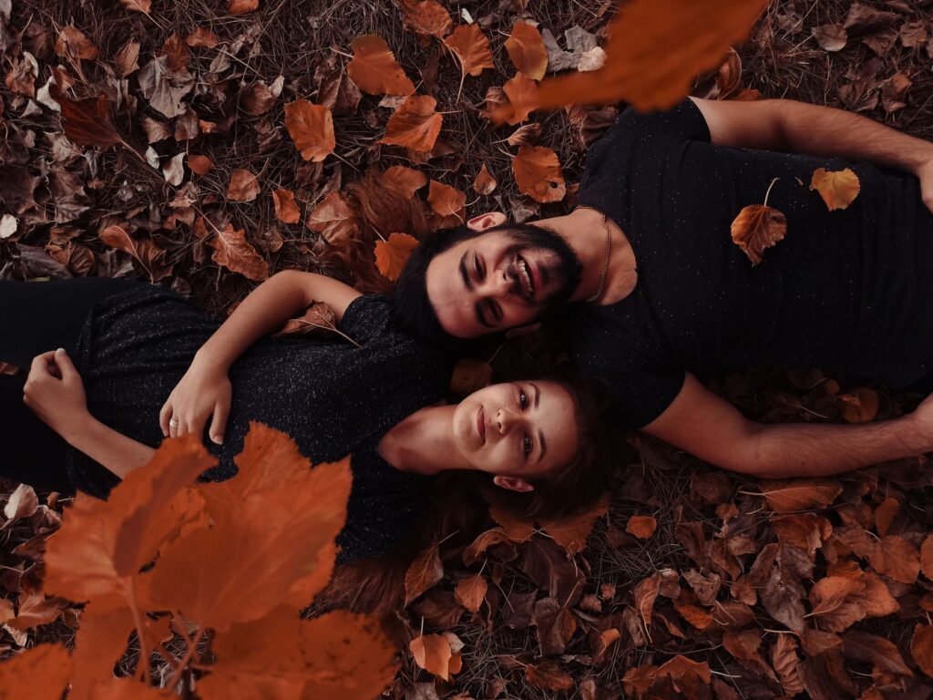 Happy couple lying together on autumn leaves in Fethiye, Türkiye. Capturing the essence of fall romance.