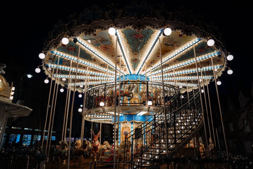 A beautifully lit carousel glows against the night sky in Oxford, England, capturing a magical fairground scene.