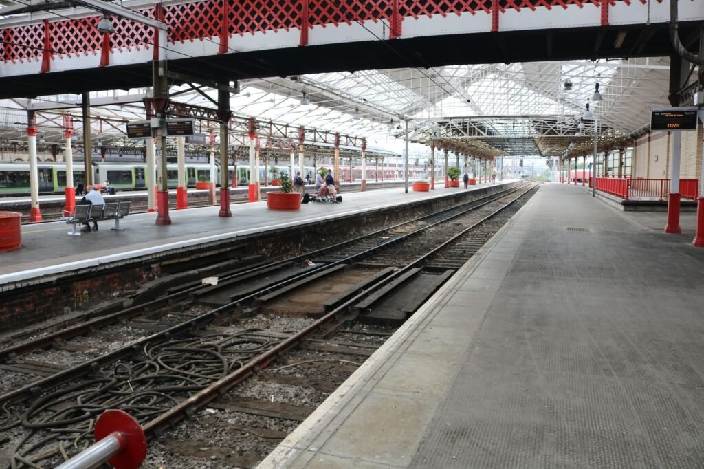A classic train station platform in England with empty tracks and historical architecture.