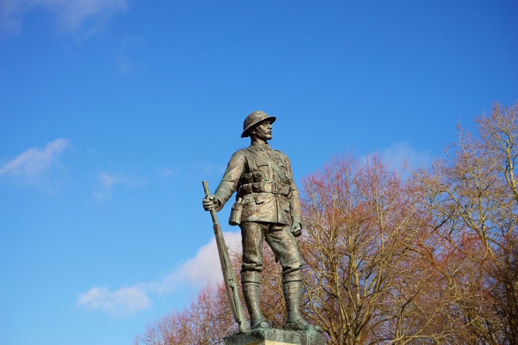 A soldier statue stands proudly against a clear blue sky in England.