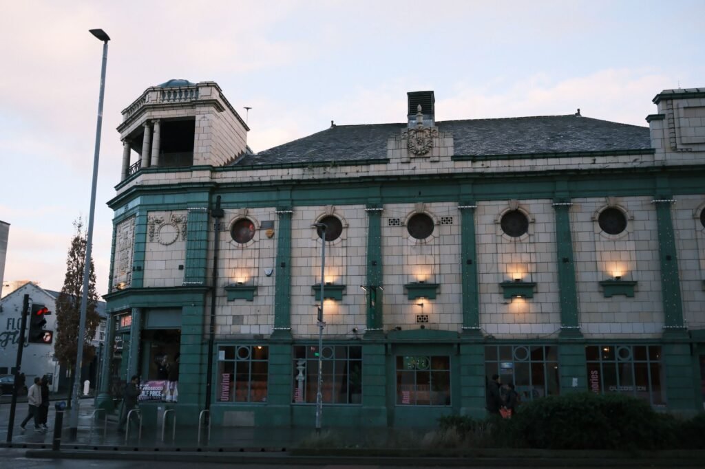 Historic theater building with intricate vintage architecture illuminated during the day.